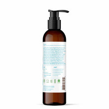 Dark amber glass bottle with black pump dispenser containing light-colored lotion and product label with text and certificati