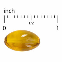 Yellow oval softgel capsule shown next to ruler for size reference.