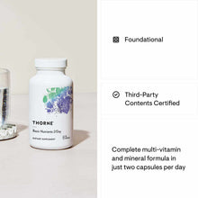 White supplement bottle labeled "THORNE Basic Nutrients 2/Day" with colorful watercolor design and white cap.