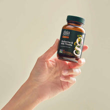 Gaia Herbs Berberine & Milk Thistle supplement bottle held in hand against neutral background.