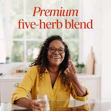 Woman in yellow shirt holding water glass with text "Premium five-herb blend" overlaid on bright kitchen background.