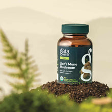 Gaia Herbs Lion's Mane Mushroom bottle with green cap containing 40 vegan capsules, displayed on soil with plants in backgrou