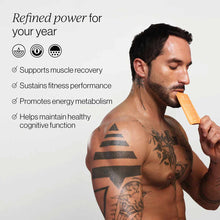 Man with tattoos holding tan-colored supplement packet near mouth, with product benefits listed on left side.