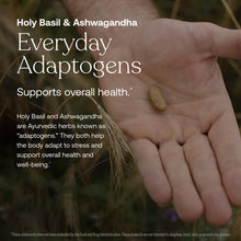 Single tan supplement capsule resting in open palm with blurred foliage background.