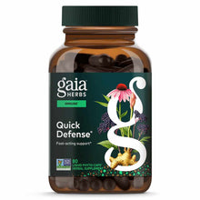 Amber glass bottle of Gaia Herbs Quick Defense herbal supplement with green cap and dark capsules inside.