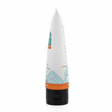 White tube with orange and teal branding, black base cap, pointed top dispenser for facial mud product.