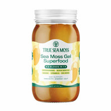 Clear glass jar with white metal lid containing golden-brown sea moss gel, labeled "True Sea Moss" with ingredient and benefi
