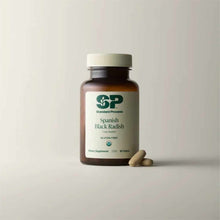 Brown glass bottle of Standard Process Spanish Black Radish dietary supplement with white cap and two tablets displayed besid