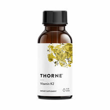 Brown glass bottle with black cap labeled "Thorne Vitamin K2 Dietary Supplement, 1 fl oz."