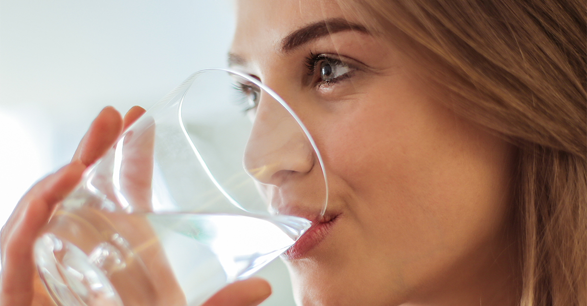 A women drinking water out of a glass