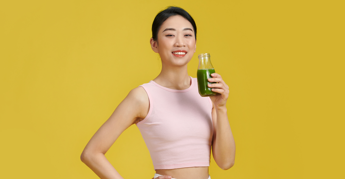 Asian woman drinking green smoothie