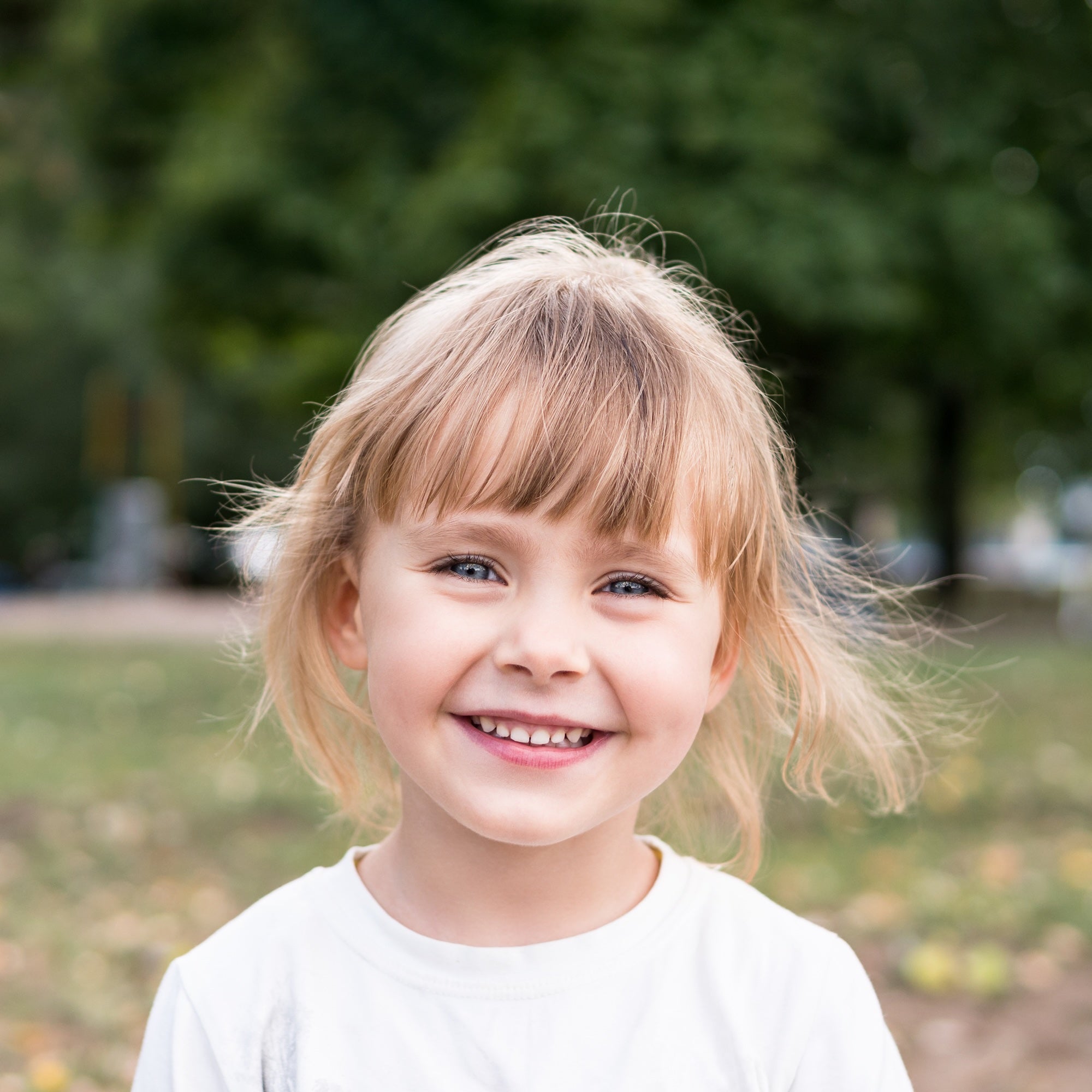 A young girl smiling outdoors