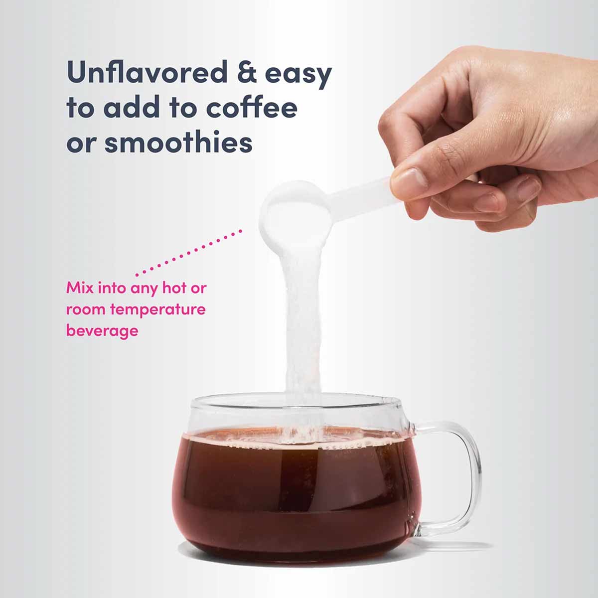 Hand holding scoop of white powder being poured into dark coffee in glass mug.