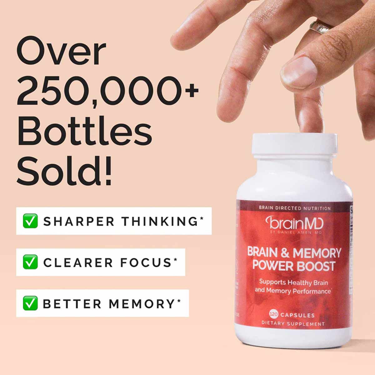 White bottle with red label held by hand showing BrainMD Brain & Memory Power Boost capsules supplement.