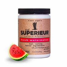 Superieur Electrolytes powder canister with black lid and cork-textured label in fresh watermelon flavor, displayed with wate