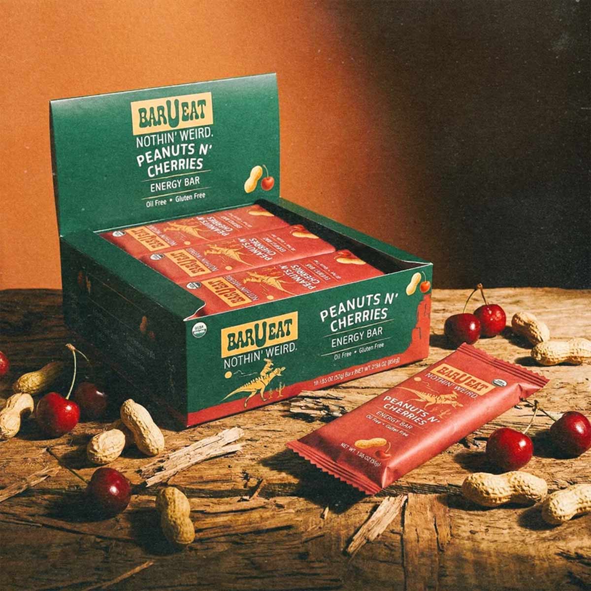 BAR U EAT Peanuts n' Cherries energy bar box with individual red wrapper bars surrounded by peanuts and cherries.