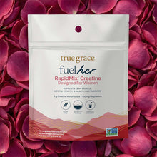 White pouch of True Grace FuelHer RapidMix Creatine powder on pink rose petal background, displaying product label and benefi