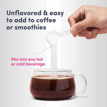 Hand holding white scoop pouring collagen peptides into mug of dark coffee.