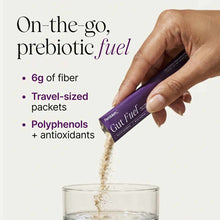 Purple Gut Fuel packet being poured into a glass of water, showing tan-colored powder.