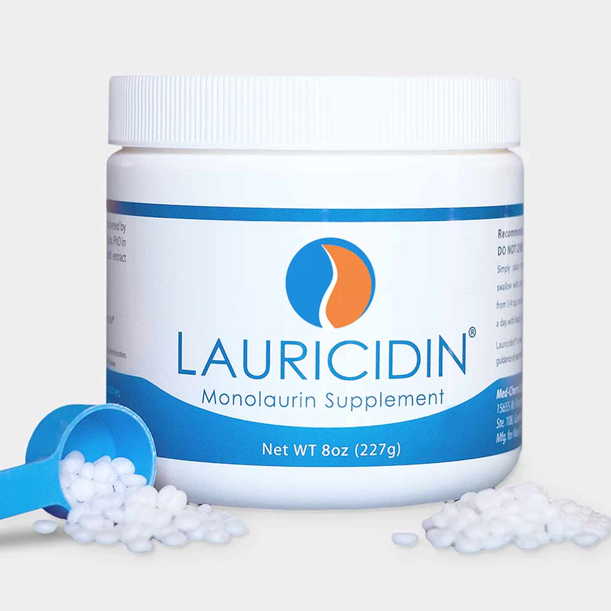 White plastic jar with blue label containing Lauricidin Monolaurin Supplement, with white pellets spilling from blue measurin