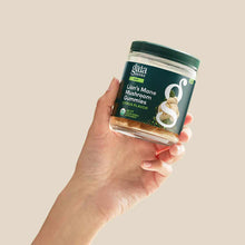 Hand holding a dark green jar of Gaia Herbs Lion's Mane Mushroom Gummies with citrus flavor label visible.