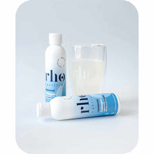 Rho Nutrition liposomal collagen supplement bottles displayed with a glass of white liquid on gray background.