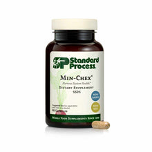 Brown glass bottle of Standard Process Min-Chex dietary supplement with cream cap and one capsule displayed beside it.