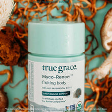 Myco-Renew fruiting body supplement jar with mint-green lid on turquoise background with orange dried mushrooms.