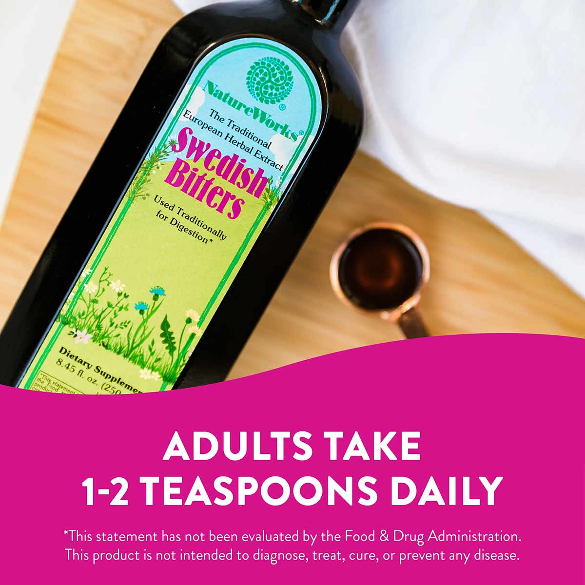 Black glass bottle of NatureWorks Swedish Bitters herbal extract with yellow-green label on wooden surface.