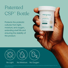 White bottle of True Grace One Daily Probiotic held in hand against teal background.