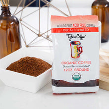 Tylers Coffee 12 oz organic decaffeinated ground coffee package next to white bowl of ground coffee.
