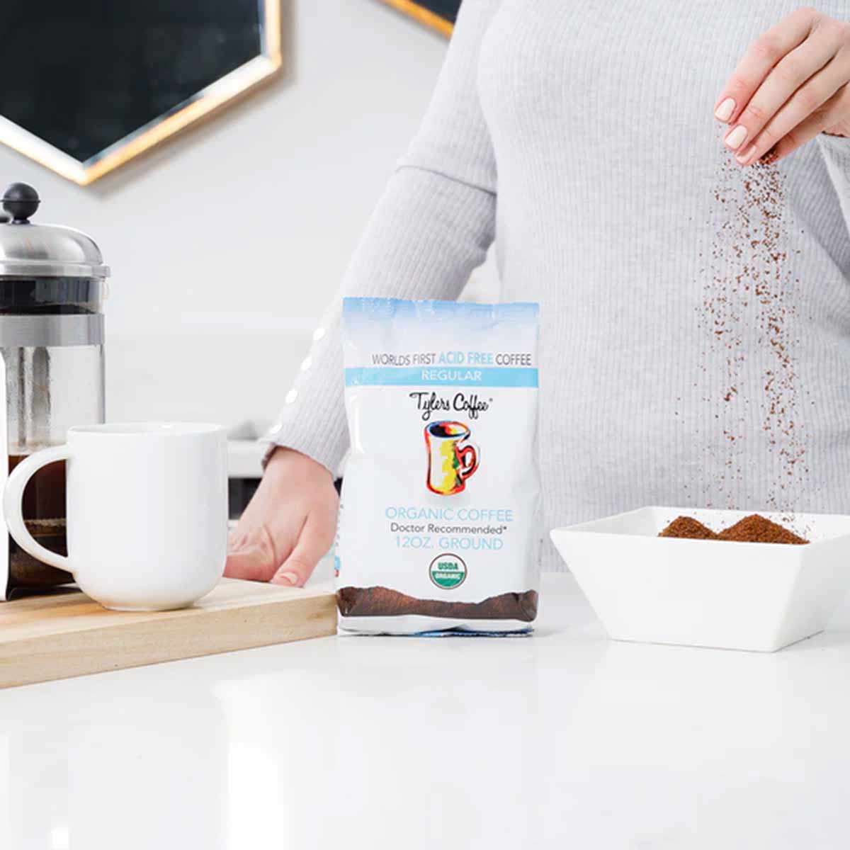 Tyler's Coffee 12 oz organic ground coffee bag being poured into a white bowl on a kitchen counter.