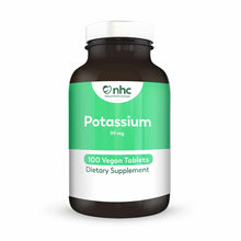 Dark glass potassium supplement bottle with green and white label showing 99 mg potassium, 100 vegan tablets, and NHC brandin