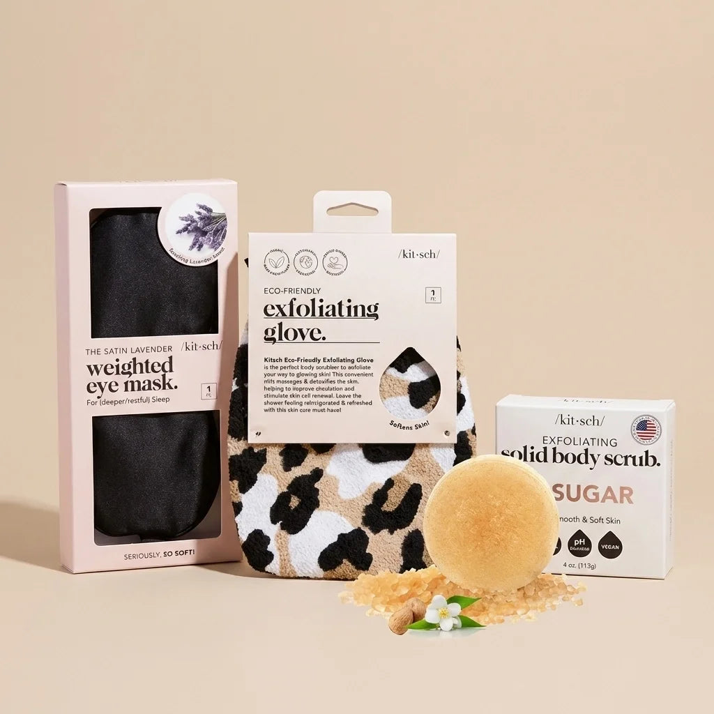Three Kitsch skincare products: black satin eye mask, leopard-print exfoliating glove, and sugar body scrub with natural ingr