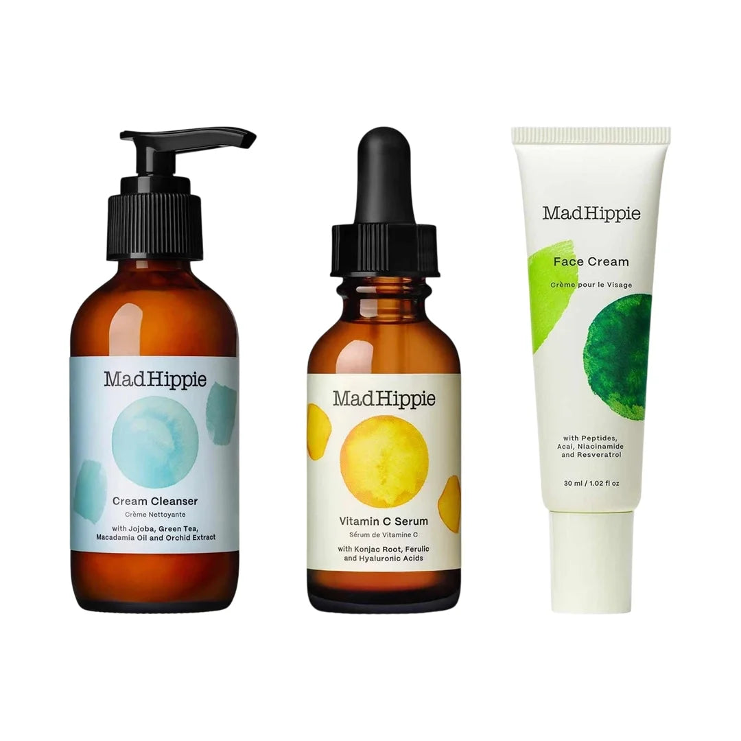 Mad Hippie skincare set with cream cleanser in amber bottle, vitamin C serum in amber dropper bottle, and face cream in white