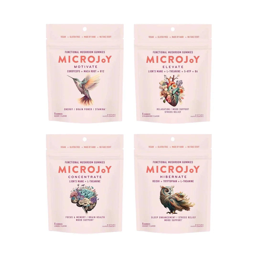 Four pink MicroJoy functional mushroom gummy pouches with illustrated hummingbird, heart, brain, and owl designs.