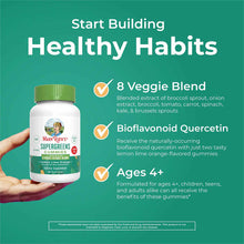 Bottle of MaryRuth's Super Greens Gummies held in hand against teal background with product benefits listed.