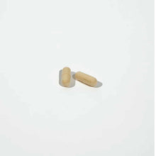 Two tan capsules on a white background.