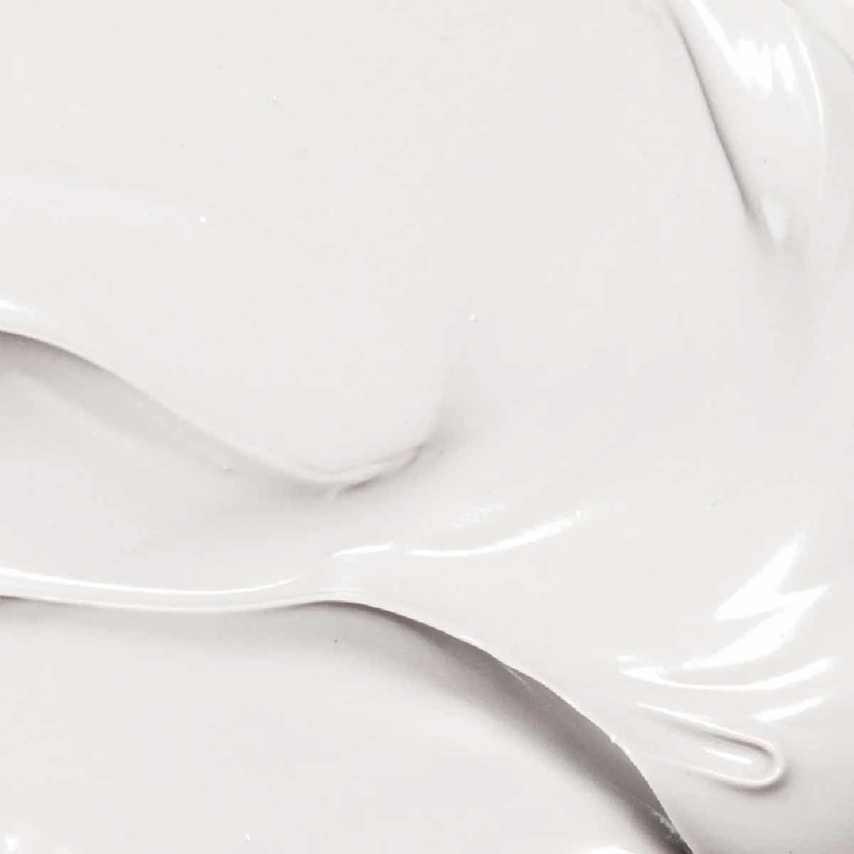 Creamy white lotion with smooth, glossy texture swirled against a neutral background.